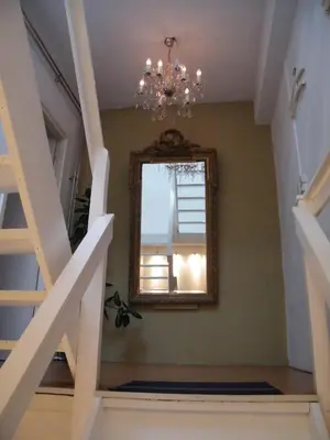 a mirror on a wall next to a stairway at La Perle Apartment in Utrecht