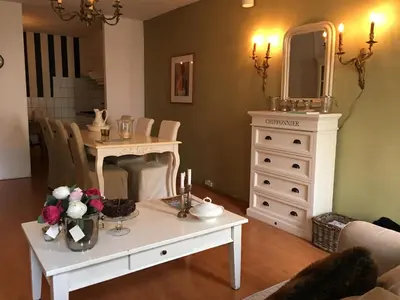 a living room with a table and a mirror at La Perle Apartment in Utrecht