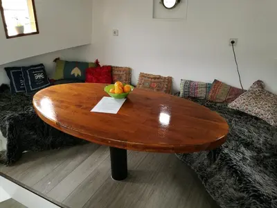 a table in a living room with a couch and a bowl of fruit at houseboat Rose in Amsterdam