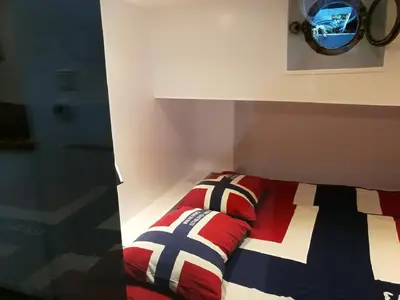 a bedroom with a bed with a colorful blanket at houseboat Rose in Amsterdam