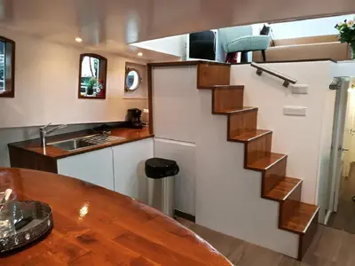 a kitchen with a spiral staircase in a tiny house at houseboat Rose in Amsterdam