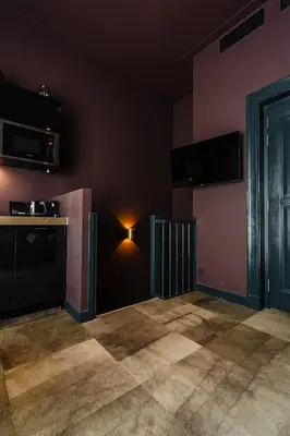 a kitchen with pink walls and a light on the wall at De Jonker Urban Suites in Amsterdam