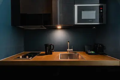 a kitchen counter with a sink and a microwave at De Jonker Urban Suites in Amsterdam
