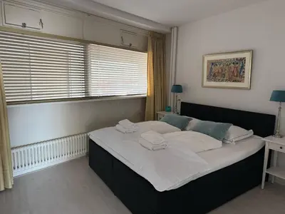 a bedroom with a large bed with two towels on it at Seaview 15 in Zandvoort