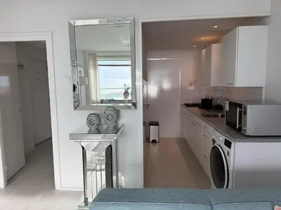 a white kitchen with a sink and a microwave at Seaview 15 in Zandvoort