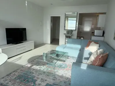 a living room with a blue couch and a television at Seaview 15 in Zandvoort