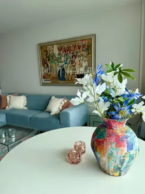 a vase with flowers on a table in a living room at Seaview 15 in Zandvoort