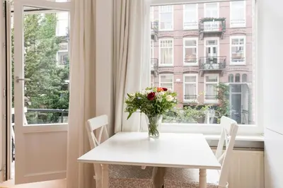 a vase of flowers on a table in front of a window at Old / New Pijp in Amsterdam