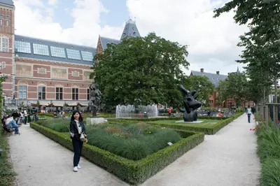 a woman walking through a garden in front of a building at Old / New Pijp in Amsterdam