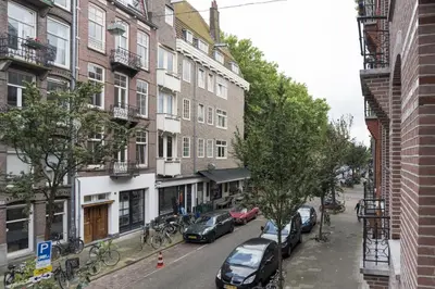 a city street with parked cars and buildings at Old / New Pijp in Amsterdam