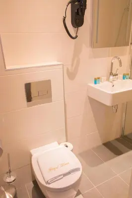 a bathroom with a toilet and a sink at Royal Plaza Hotel Amsterdam in Amsterdam
