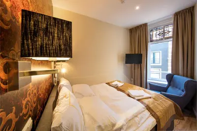 a hotel room with a bed and a chair at Royal Plaza Hotel Amsterdam in Amsterdam