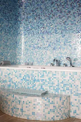 a bathroom with a tub with blue and white tiles at Vitamine Zee in IJmuiden