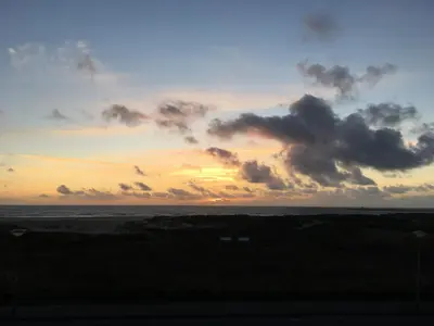 a sunset over the ocean with clouds in the sky at Vitamine Zee in IJmuiden