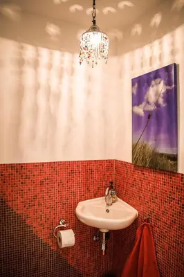 a bathroom with a sink and a chandelier at Vitamine Zee in IJmuiden