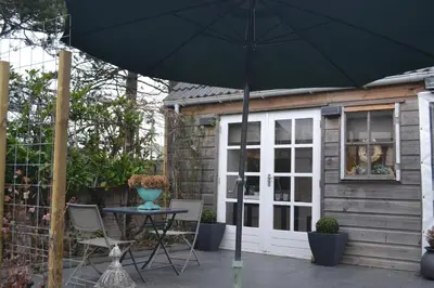 a patio with a table and an umbrella at Studio@25 in Zandvoort