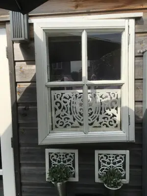 a window on the side of a house with two plants at Studio@25 in Zandvoort