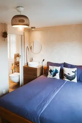 a bedroom with a blue bed and a sink at Villa La Vida in Egmond aan Zee