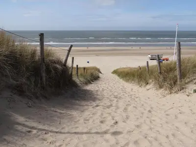 a sandy path leading to a beach with the ocean at Villa La Vida in Egmond aan Zee