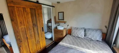 a bedroom with a bed and a wooden door at Villa La Vida in Egmond aan Zee