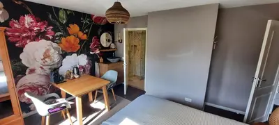 a room with a table and a flower mural on the wall at Villa La Vida in Egmond aan Zee