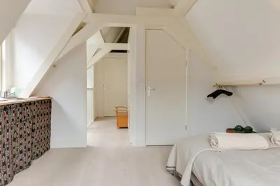 a white room with two beds and a door at Rembrandt Studio's in Amsterdam
