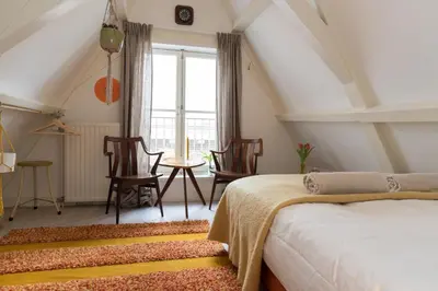 a bedroom with a bed and a table and chairs at Rembrandt Studio's in Amsterdam