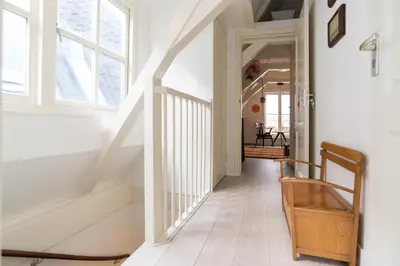 a hallway with a white staircase with a window at Rembrandt Studio's in Amsterdam