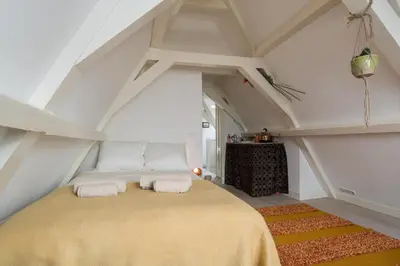 a bedroom with a large bed in an attic at Rembrandt Studio's in Amsterdam