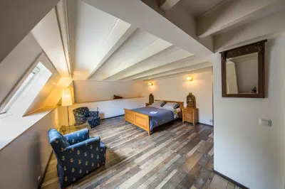 a bedroom with a bed and a chair and a mirror at de zanderij in 's-Graveland