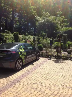 a car parked in front of a fence at de zanderij in 's-Graveland