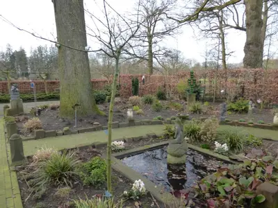 a garden with a pond with a bird in it at de zanderij in 's-Graveland