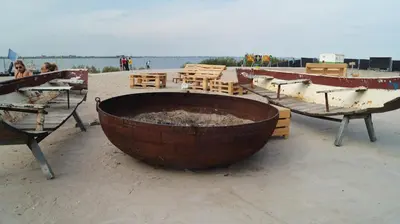 a large barrel on a beach with tables and boats at Room With A Few in Amsterdam
