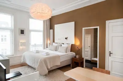 a bedroom with a white bed and a large chandelier at The Market Retreat in Amsterdam
