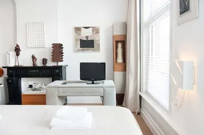 a bedroom with a bed and a tv and a chair at The Market Retreat in Amsterdam