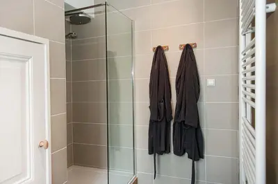 a bathroom with a shower with a glass door at The Market Retreat in Amsterdam