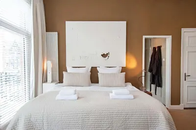 a bedroom with a large white bed with towels on it at The Market Retreat in Amsterdam