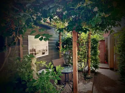 a patio with a table and a tree at Beach Holiday Appartements in Dirkshorn