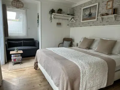 a bedroom with a large bed and a couch at Beach Holiday Appartements in Dirkshorn