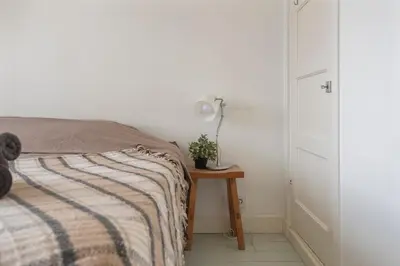 a bedroom with a bed and a table with a lamp at Wijkiki Surf House in Wijk aan Zee
