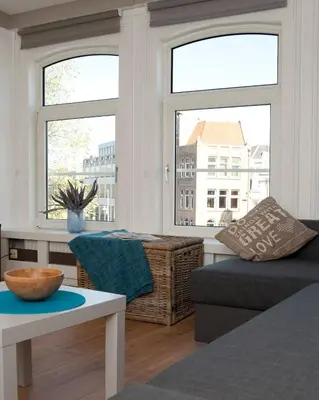 a living room with a couch and two windows at Residence Flower Market in Amsterdam