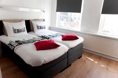 a bedroom with two beds with red pillows at Residence Flower Market in Amsterdam