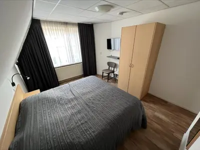 a bedroom with a bed and a cabinet in it at Appartement 5 in Katwijk aan Zee