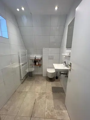 a white bathroom with two sinks and a toilet at Appartement 5 in Katwijk aan Zee