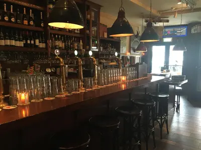 a bar with several empty glasses on a counter at Beach Hotel Katwijk in Katwijk