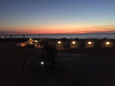 a sunset view of a row of beach huts at Beach Hotel Katwijk in Katwijk