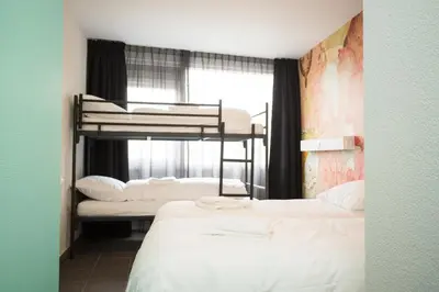 a room with two bunk beds and a window at Beach Hotel Katwijk in Katwijk