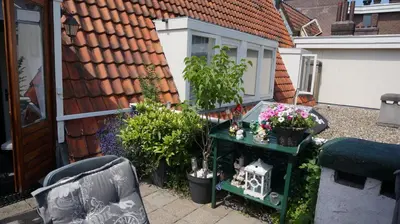a patio with a table with flowers and plants at Amsterdam Roof Terrace B&B in Amsterdam