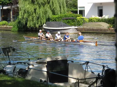 a group of people rowing a boat on the water at Amsterdam Roof Terrace B&B in Amsterdam