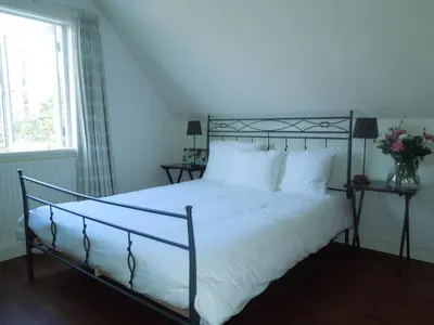 a bedroom with a bed with white sheets and a window at Bed & Breakfast Frans Hals Haarlem in Haarlem